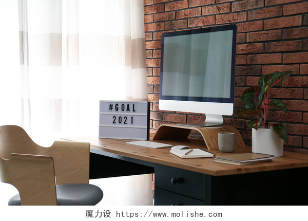 简约装饰的家居办公桌带有hashtag的灯箱2021年目标靠近办公室木制桌子上的计算机监视器